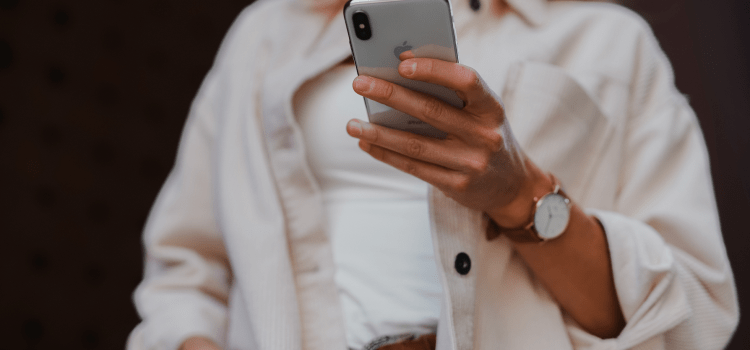 woman using mobile phone in white shirt