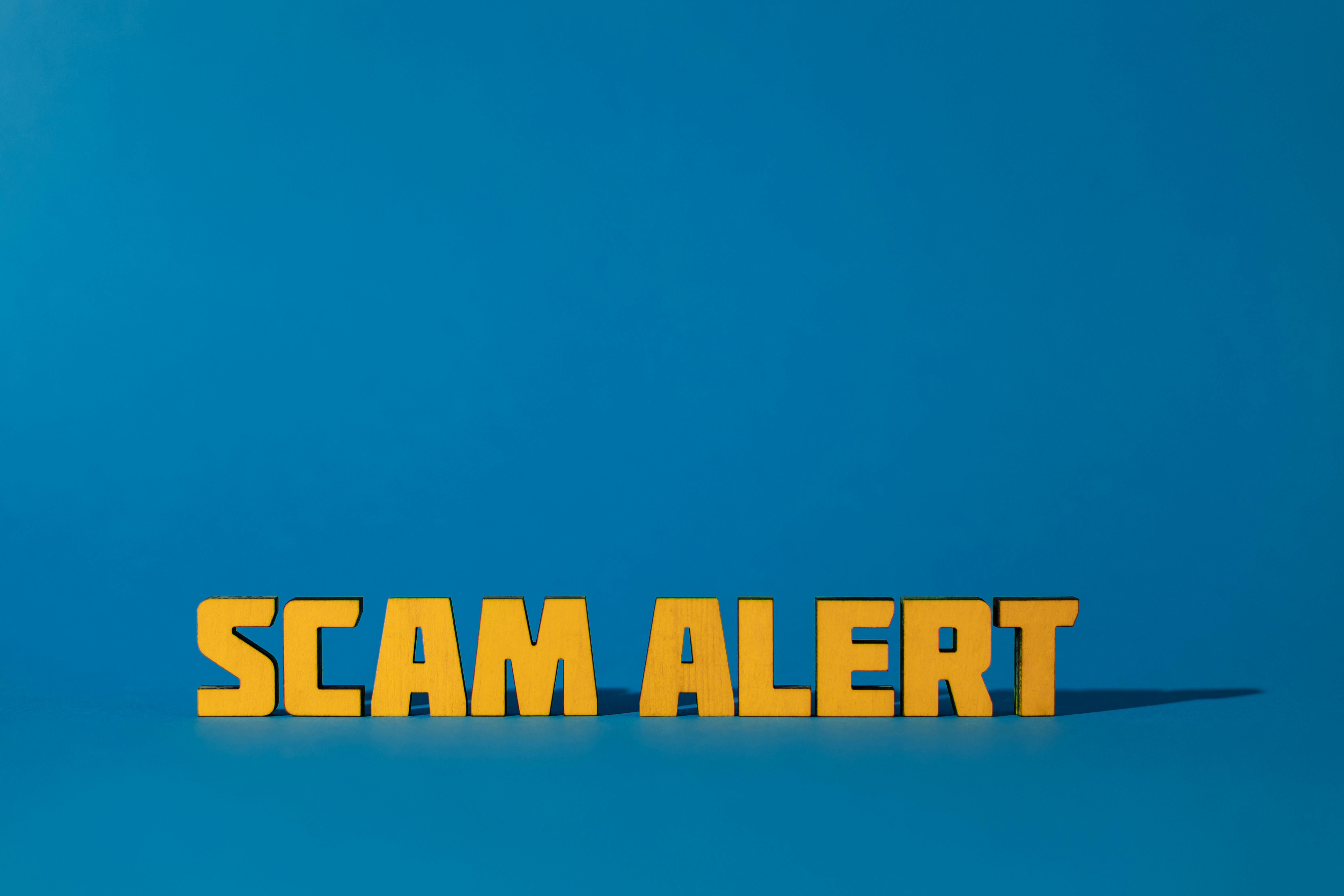 Scam alert written on a blue backround